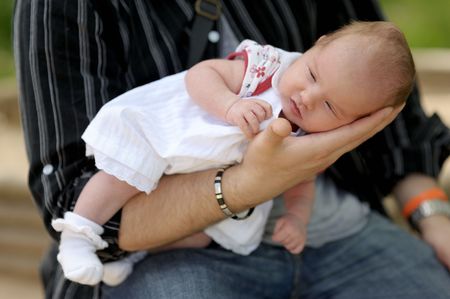 Little newborn baby being in father's hands