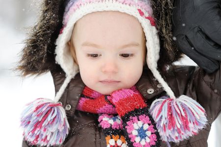 Little winter baby girl looking downの写真素材