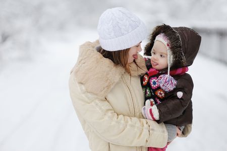 Little baby girl and her mother showing their tongues to each other