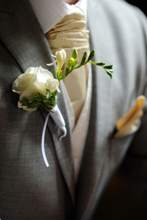 White fressia boutonniere on groomの写真素材