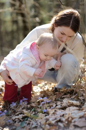 Young mother and her baby in a spring forestの写真素材