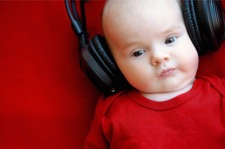Two month old baby with giant earphonesの写真素材