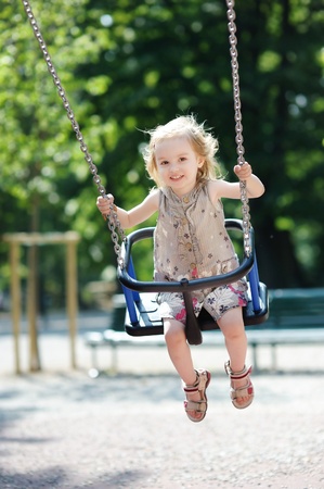 Swinging preschooler girl having funの写真素材