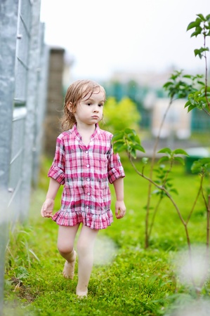 Little girl having fun under the rain in summerの写真素材