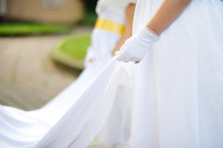 Little bridesmaids holding bride