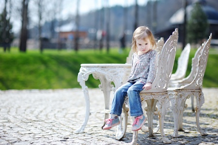 Adorable happy toddler girl sitting outdoorsの写真素材