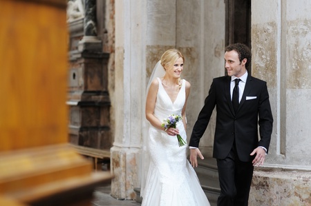 Bride and groom smiling at the church after a wedding ceremonyの写真素材