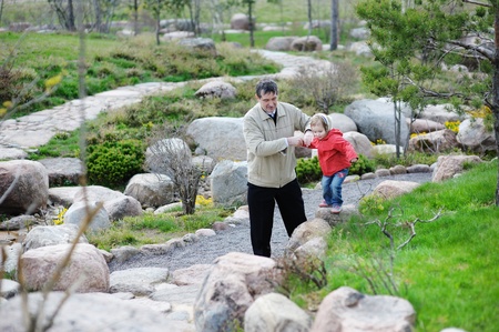 Grandfather and granddaughter walking in a spring parkの写真素材