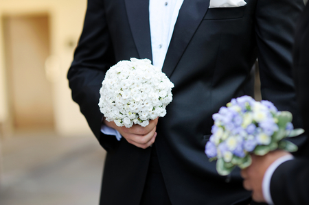 Groom and a bestman holding flowers during the wedding ceremonyの写真素材