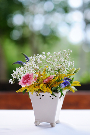 A vase full of assorted flowers outdoorsの写真素材