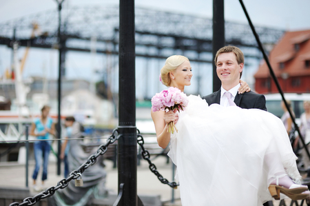 Young groom carrying his beautiful brideの写真素材