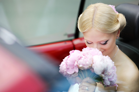 Beautiful young bride portrait in a carの写真素材