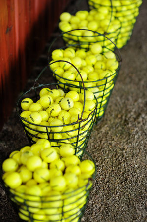 Baskets of yellow golf balls on a golf fieldの写真素材