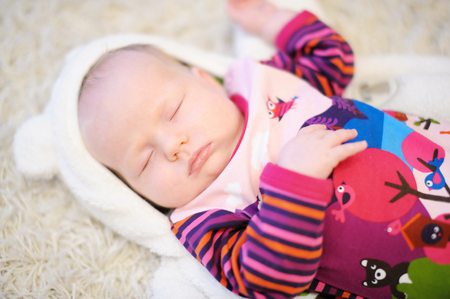 Adorable newborn baby girl in colorful bodysuit