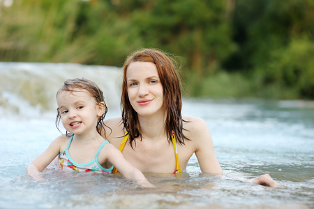 Adorable girl and her mom on a beachの写真素材