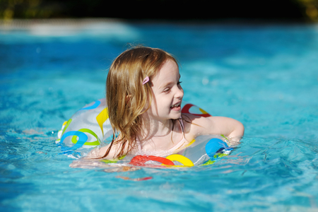 Pretty little girl swimming in outdoor poolの写真素材