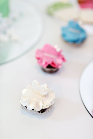Decorated colorful cupcakes on a white tableの写真素材