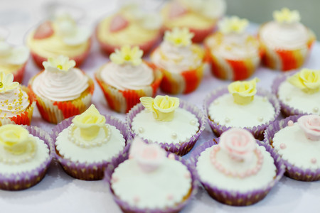 Decorated colorful cupcakes on a white tableの写真素材