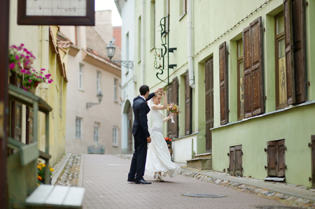 Happy bride and groom dancing on a streetの写真素材