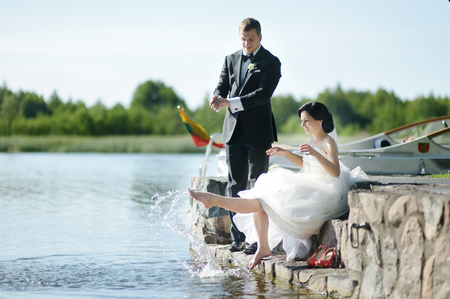 Beautiful bride and groom by a lakeの写真素材