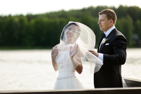 Beautiful bride and groom by a lakeの写真素材