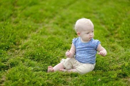 Baby girl sitting on a green grassの写真素材