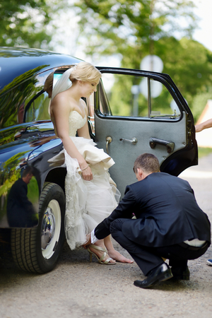 Groom helping his bride to put on her shoesの写真素材
