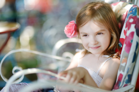Adorable little girl relaxing in outdoor restaurantの写真素材