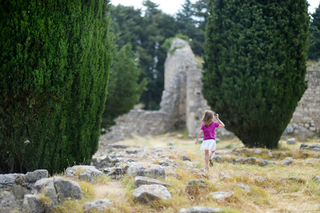 Little girl sightseeing historical ruins of Asclepieionの写真素材