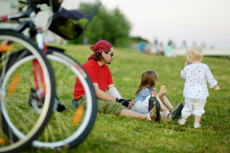 Young father and his daughters picnicking in the parkの写真素材