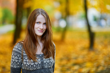 Young beautiful woman portrait outdoors on autumn dayの写真素材