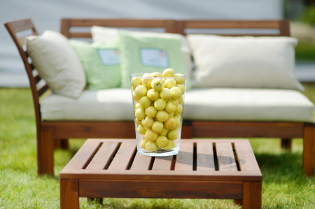 Vase full of peaches on a wooden table outdoorsの写真素材