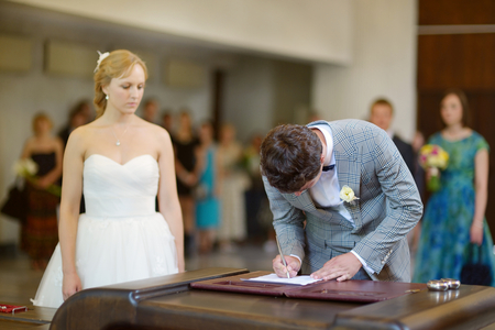 Groom signing marriage license or wedding contractの写真素材