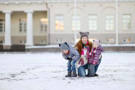 Young mother and her daughters having fun on winter dayの写真素材