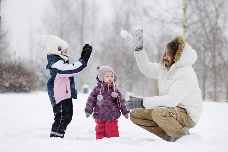 Young father and his daughters having fun on winter dayの写真素材