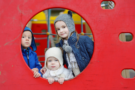 Three kids on a playground on autumn dayの写真素材
