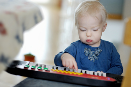 Little toddler girl playing toy pianoの写真素材