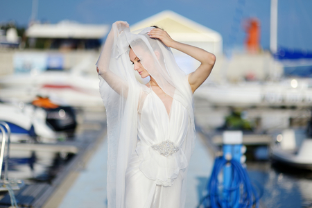Beautiful bride posing in a small harborの写真素材