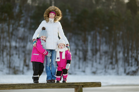 Young mother and her two daughters having fun on winter dayの写真素材