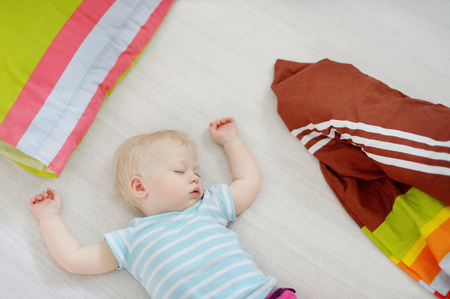 Adorable toddler girl sleeping in a bedの写真素材