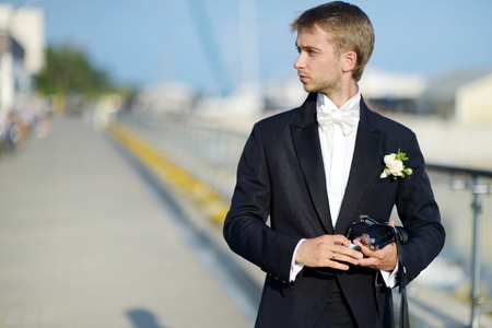 Groom taking a photo of his bride with a instant cameraの写真素材
