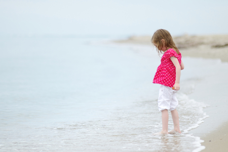 Adorable little girl on beautiful sandy beachの写真素材