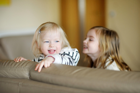 Twio little sisters having fun at homeの写真素材