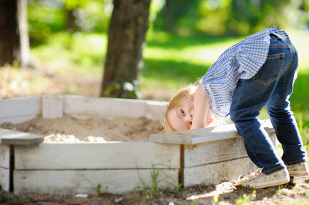 Adorable little girl playing in a sandboxの写真素材