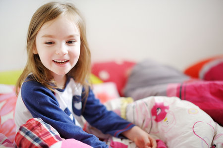 Little preschooler girl in pajamas on sunny morningの写真素材