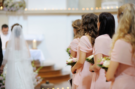 Row of bridesmaids with bouquets at wedding ceremonyの写真素材