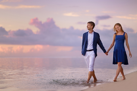 Beautiful romantic couple on a sunset on tropical beachの写真素材