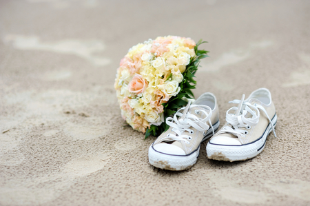 Wedding on a beach: flowers and a pair of sneakersの写真素材