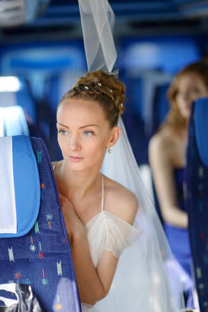 Beautiful young bride portrait in a wedding busの写真素材