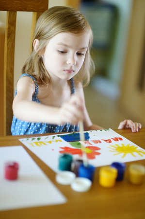 Cute little girl is drawing with paints in preschoolの写真素材